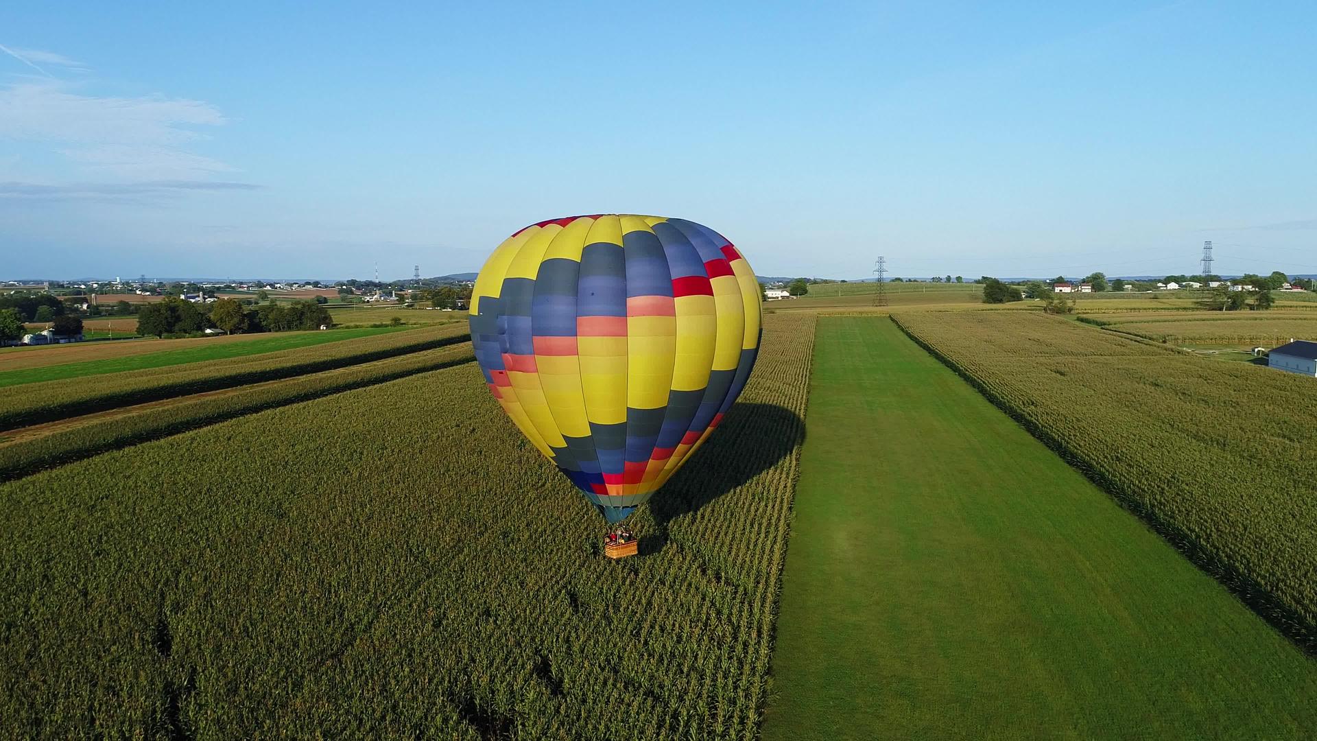 在农村阳光明媚的夏季节日期间一个热气球和一个农场玉米视频的预览图