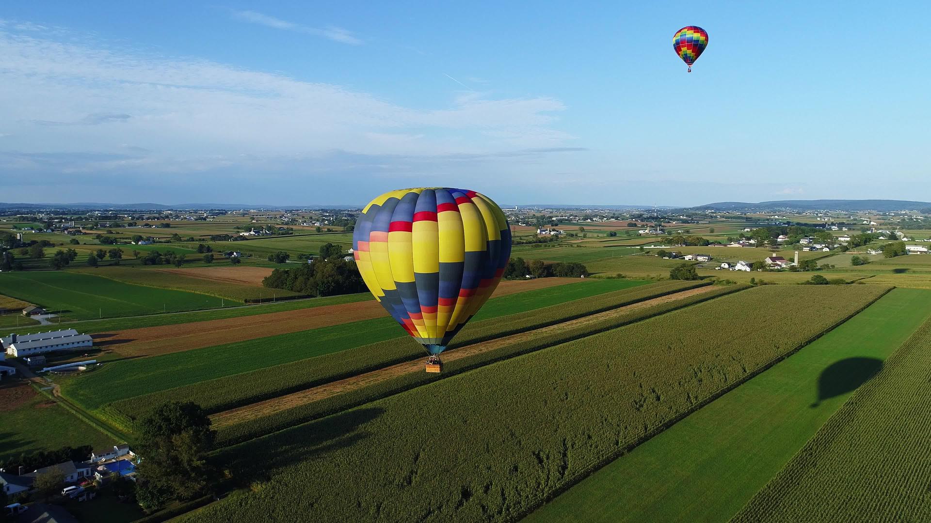 在农村阳光明媚的夏季节日热空气气球漂浮在农场上视频的预览图