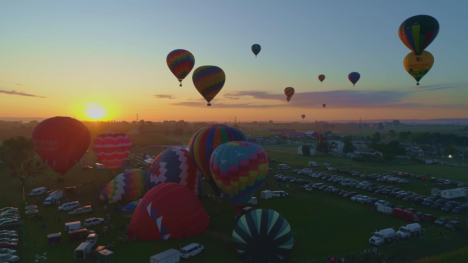 在一个阳光明媚的夏天日出在热气球节上发射就像无人机在早晨看到的那样视频的预览图