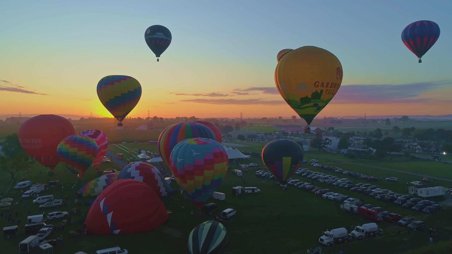 在一个阳光明媚的夏天日出在热气球节上发射就像无人机在早晨看到的那样视频的预览图