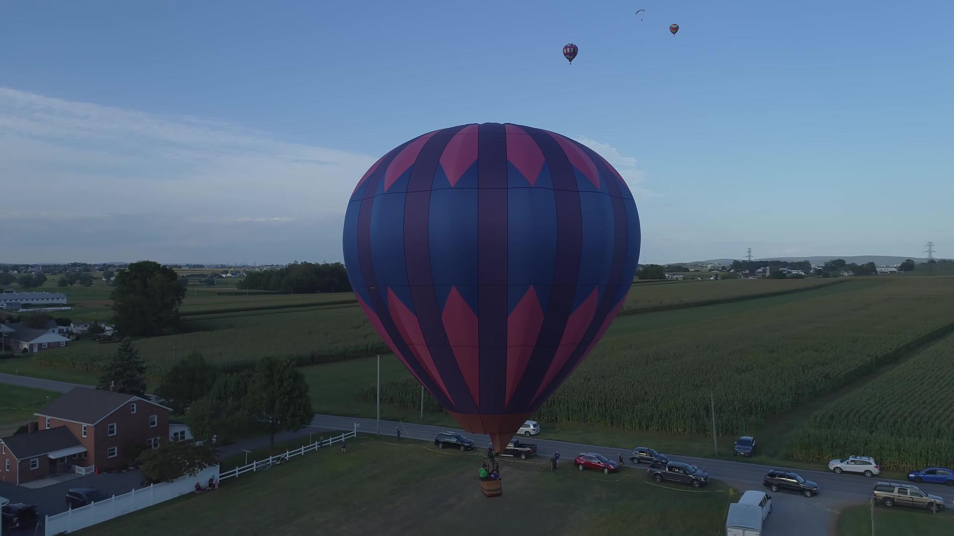 夏天阳光明媚的节日晚上农场里有一个热空气气球视频的预览图