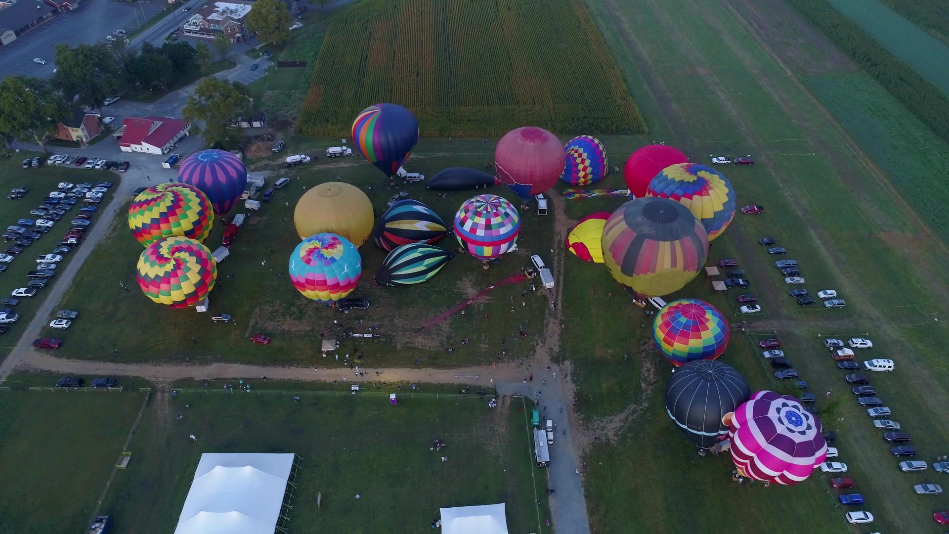 从空中俯冲下来看着许多热气球早上太阳升到节日视频的预览图
