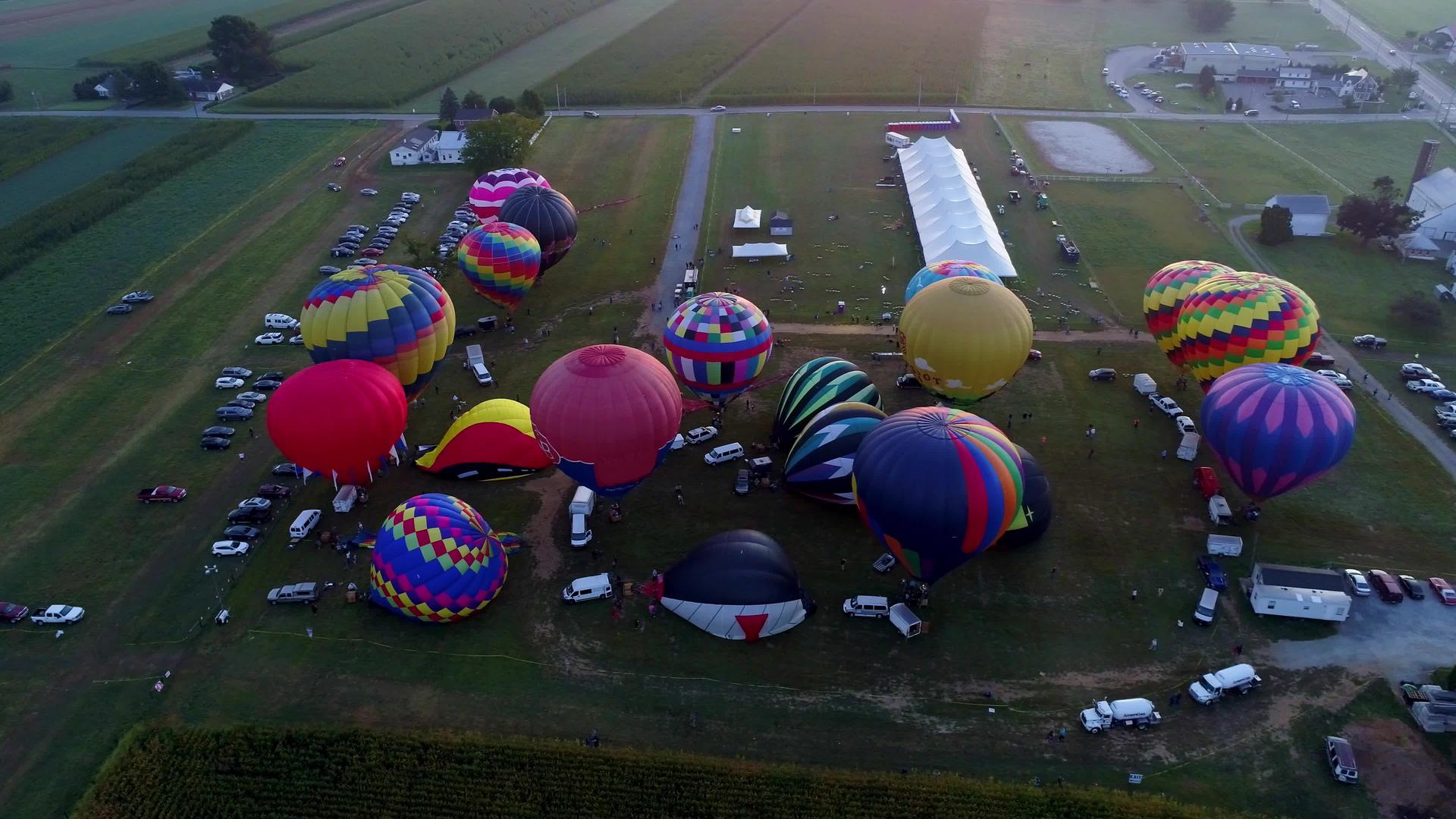 在阳光明媚的夏季节日期间许多热气球从空中俯瞰清晨许多热气球从空中俯瞰视频的预览图