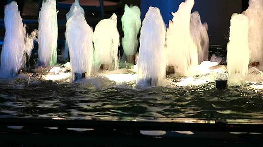 泉水喷泉穿过游泳池表面照亮夜光视频的预览图