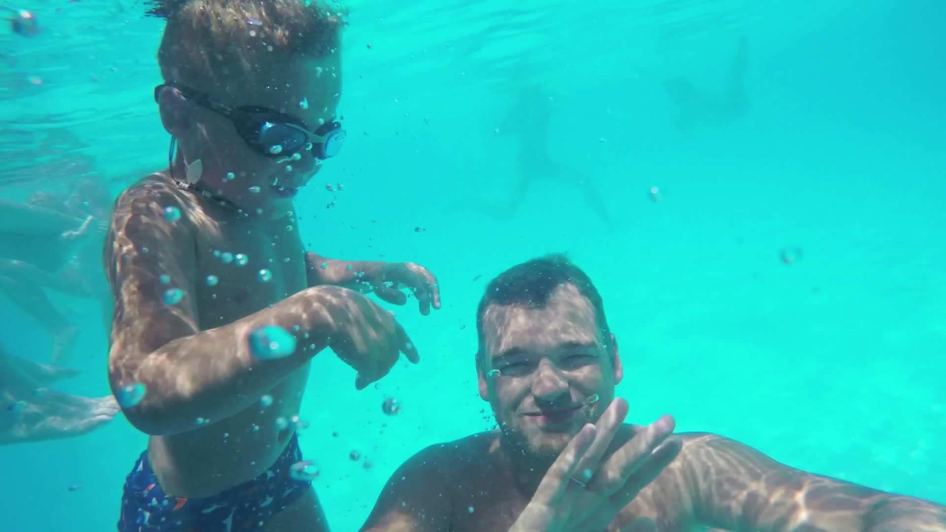 孩子和父亲在游泳池潜水时挥手视频的预览图