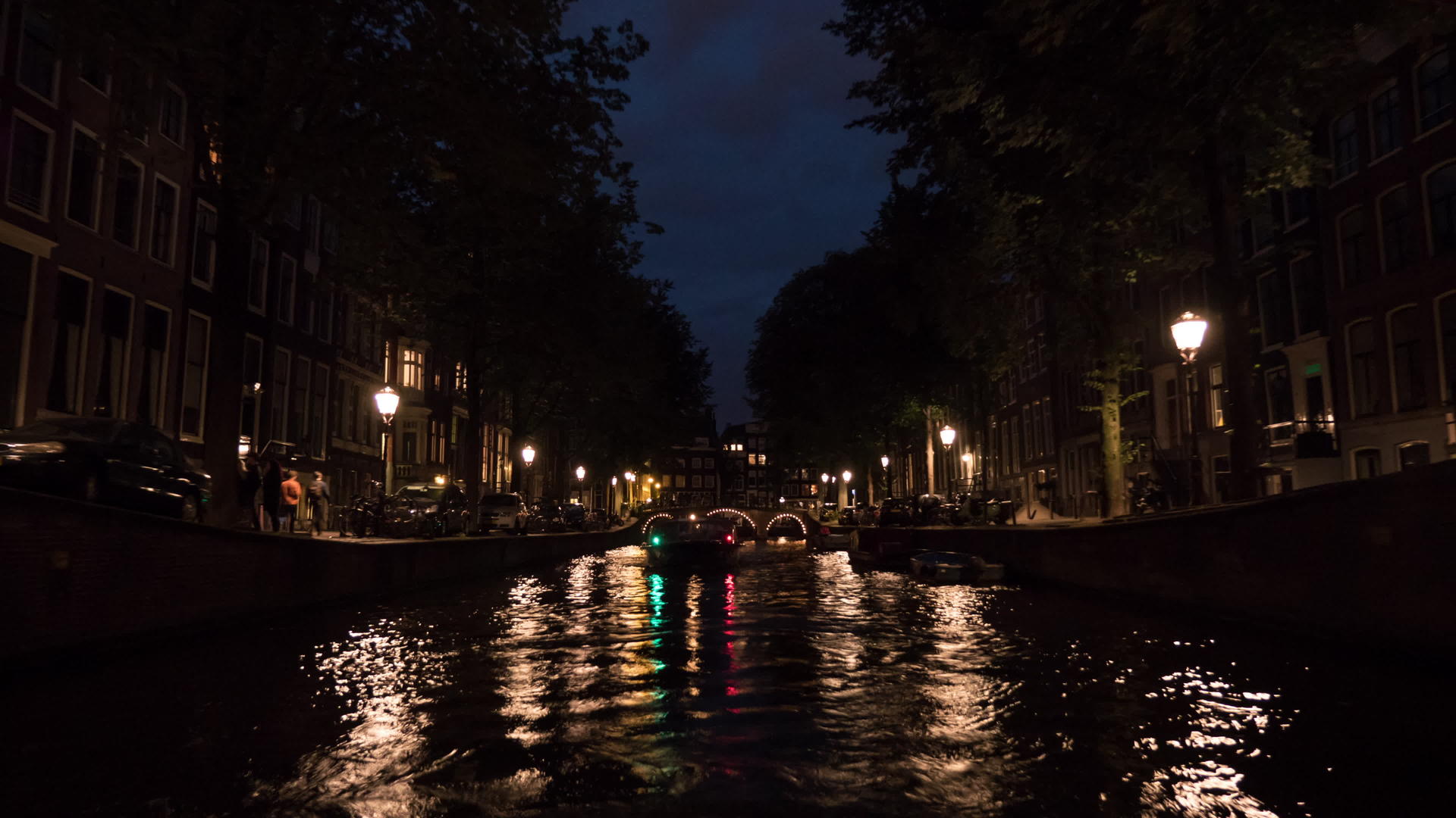 在阿姆斯特丹大陆的夜间河流巡航期间城市风景的时间视频的预览图