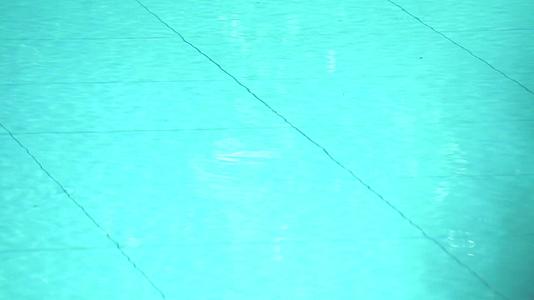 蓝色和蓝色的小波浪从结对的游泳池表面和水下潮水中浮出视频的预览图