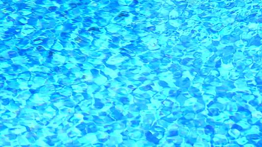 游泳池浅蓝色瓷砖中水面背景的波浪缓慢移动视频的预览图