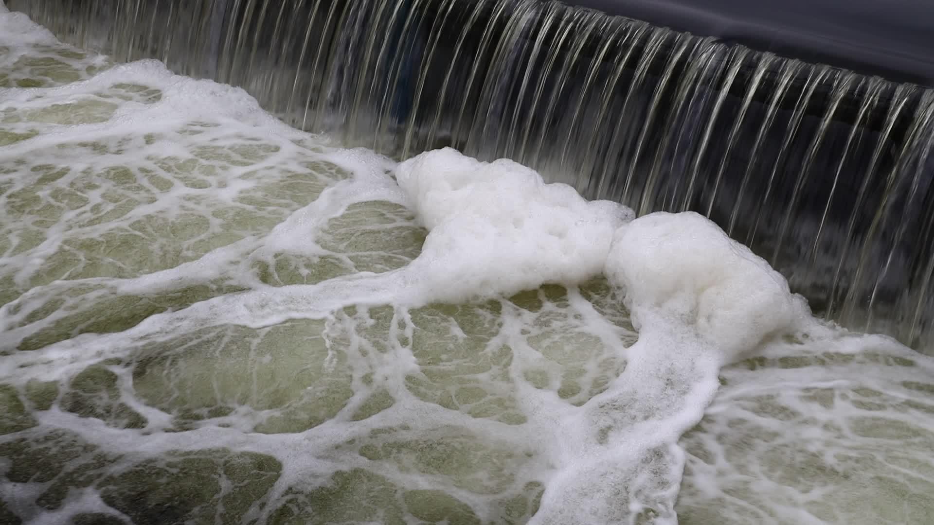 肮脏的河水从裂缝和泡沫中流出视频的预览图