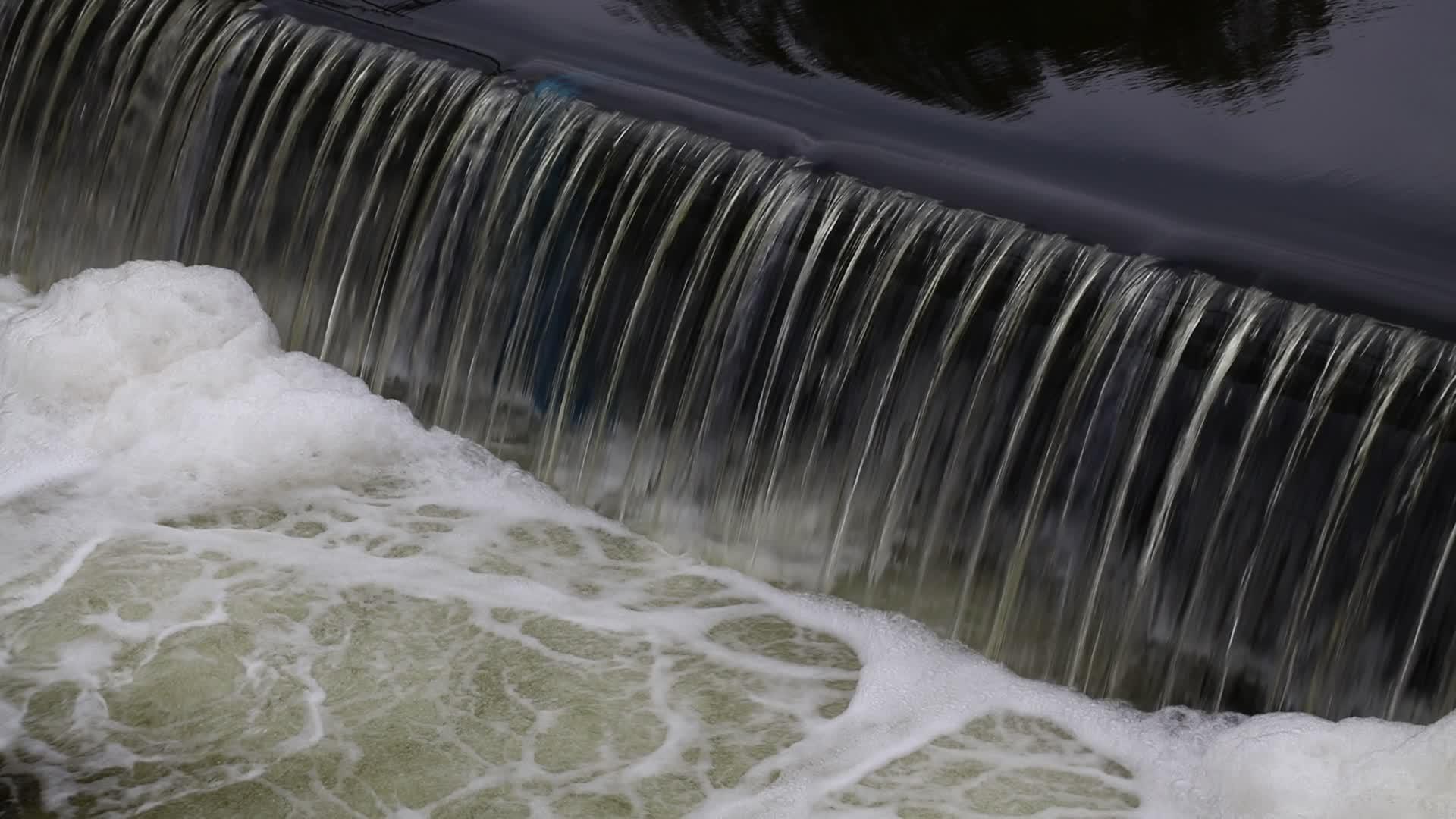 肮脏的河水从裂缝和泡沫中流出视频的预览图