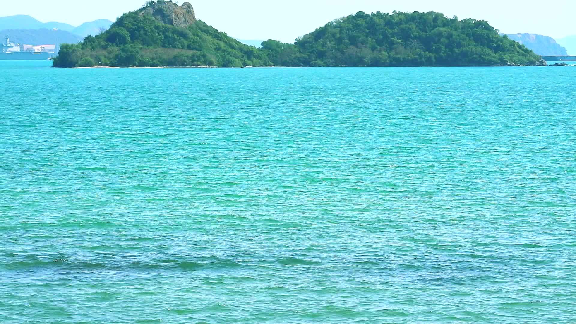 水面和岛屿上纯净的蓝色海洋的清澈波浪视频的预览图
