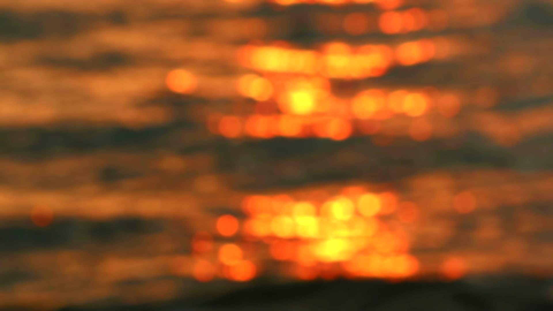 日落的红色和黄色反射着海上的波浪和水视频的预览图