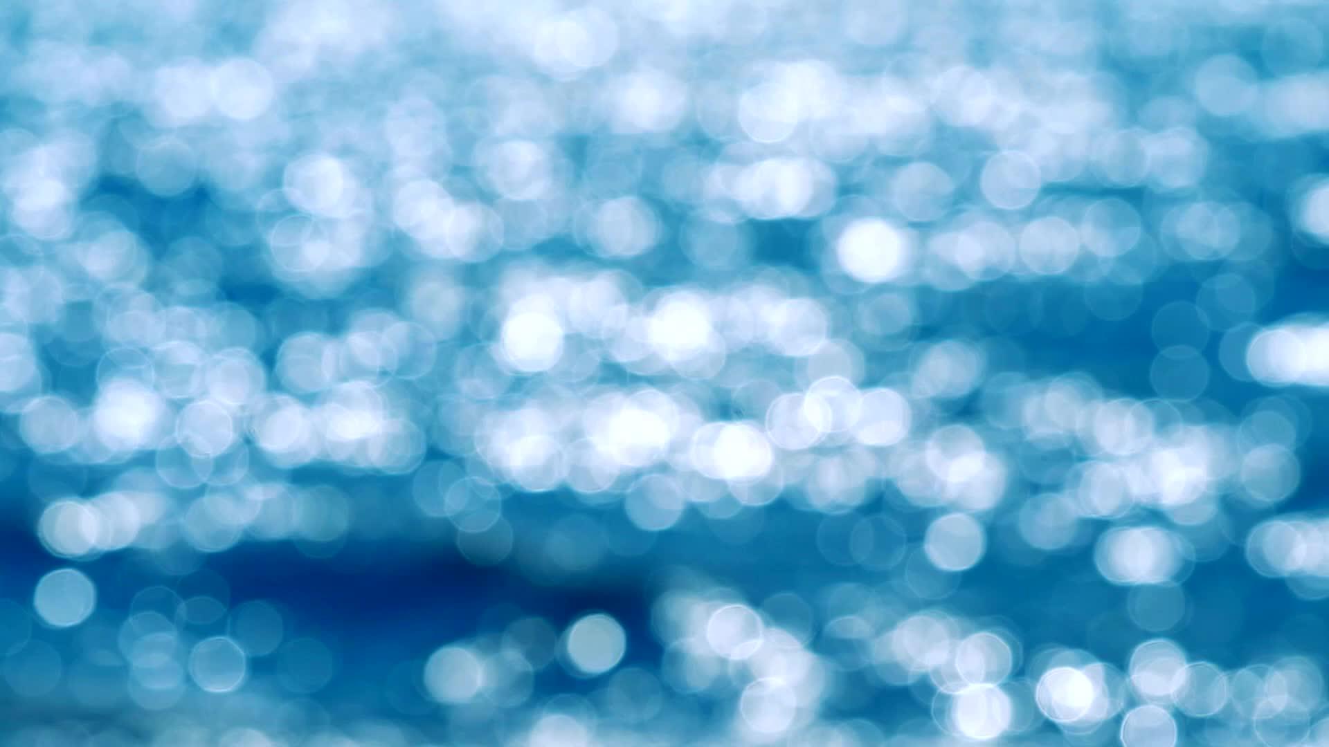 夏天的蓝色和白色bokeh闪烁背景的海浪模糊反射视频的预览图
