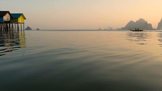 日落时渔民的房子在水域边缘上方升起视频的预览图