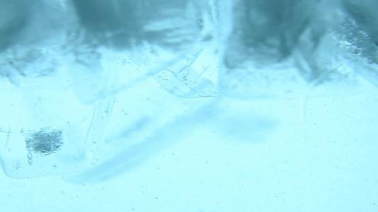 清冰立方体漂浮在蓝色的水中视频的预览图