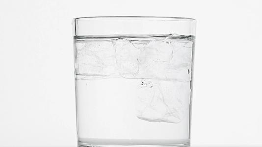 冰雪立方体在水杯中旋转高于白色视频的预览图