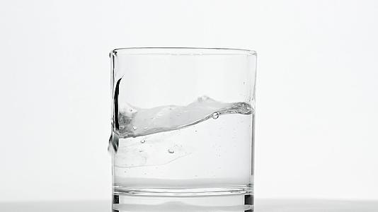 冰雪立方体倒在白色的水杯里视频的预览图