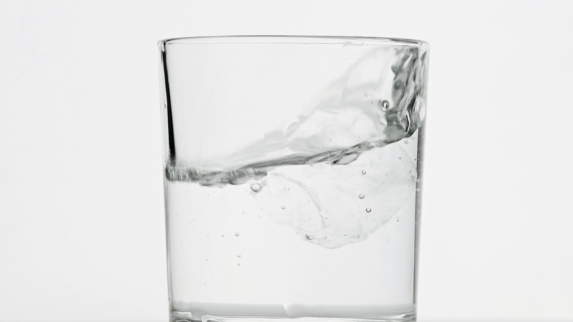 冰雪立方体倒在白色的水杯里视频的预览图