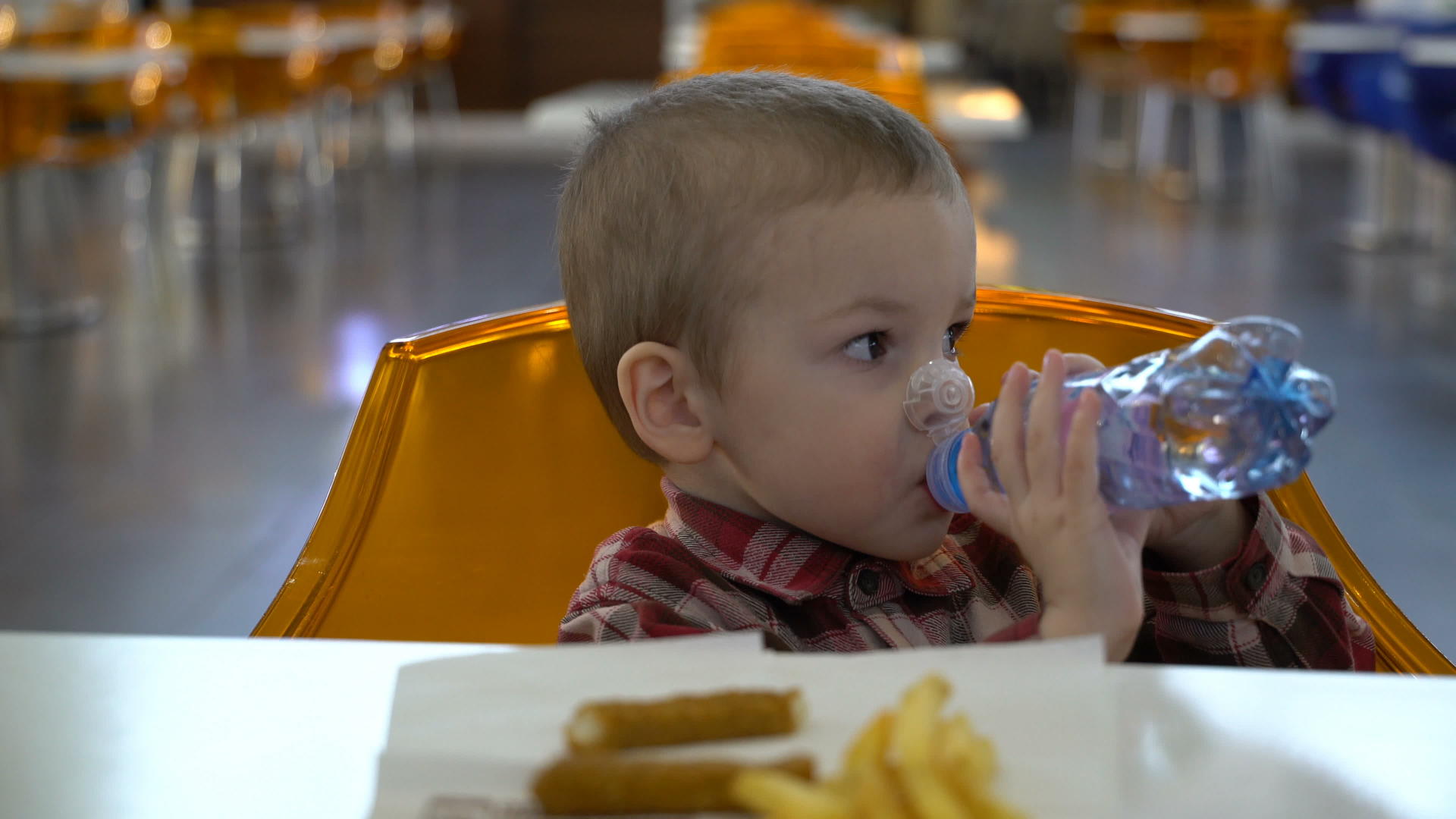 男孩在桌子上从塑料瓶里喝水视频的预览图