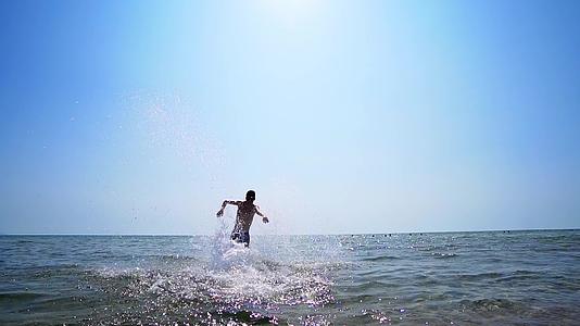 男人在海水中奔跑和跳跃Stadicam漫步拍摄视频的预览图