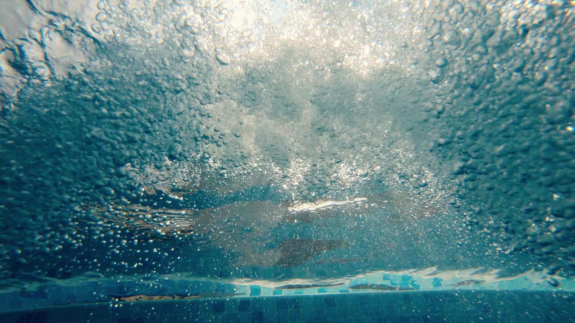 水面反射的游泳池和阳光下的气泡视频的预览图