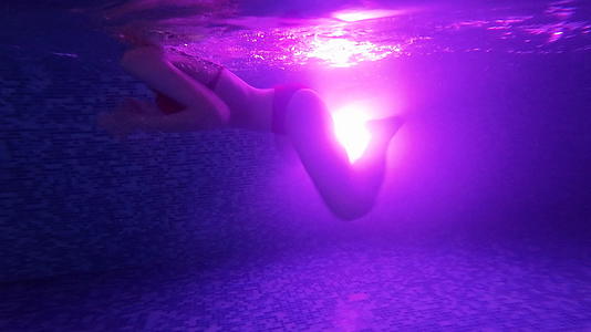 在黑暗游泳池中游泳的黑色游泳池适合女性游泳从光线向后反射视频的预览图