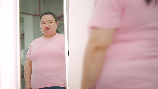 4k胖女生照镜子看身材瘦身减肥视频的预览图