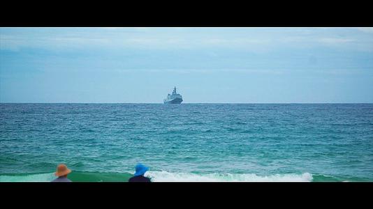 拍摄游客观海行驶在海上远方的军舰船只建军节视频的预览图