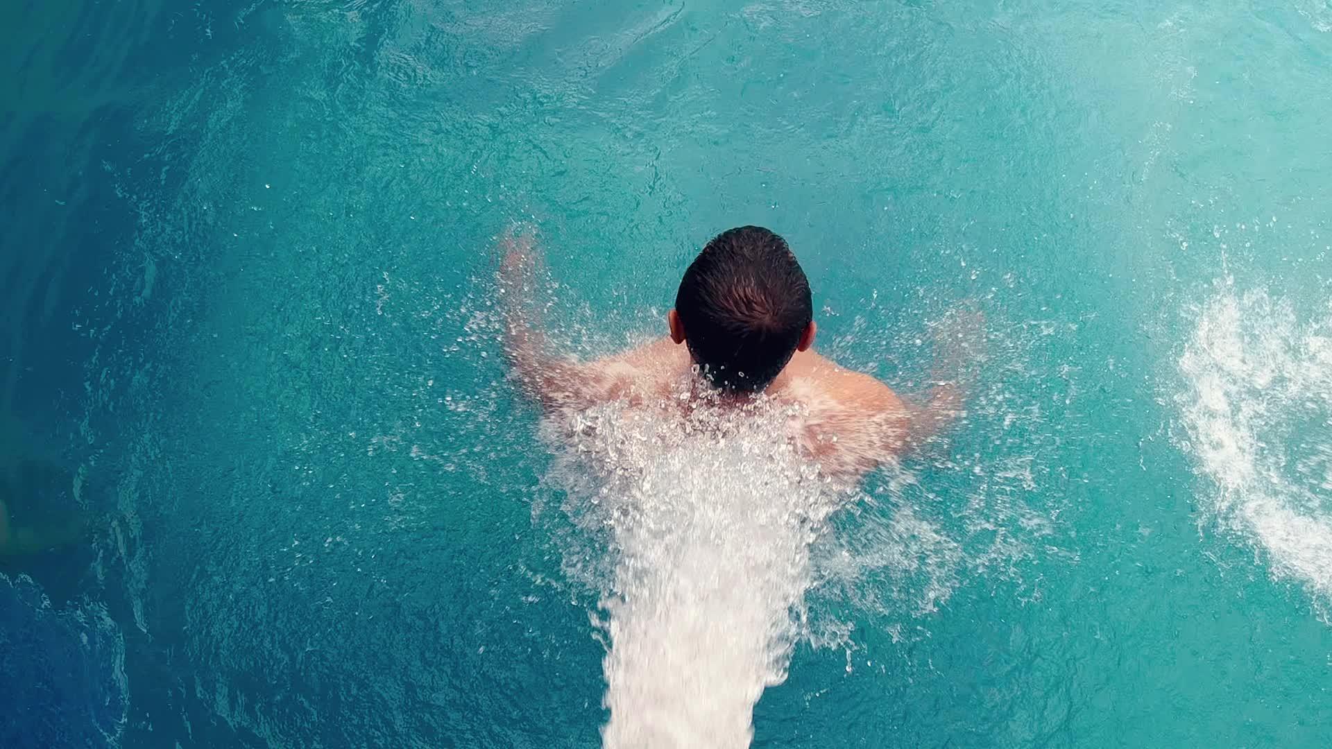 男人在游泳池的喷水器下放松视频的预览图