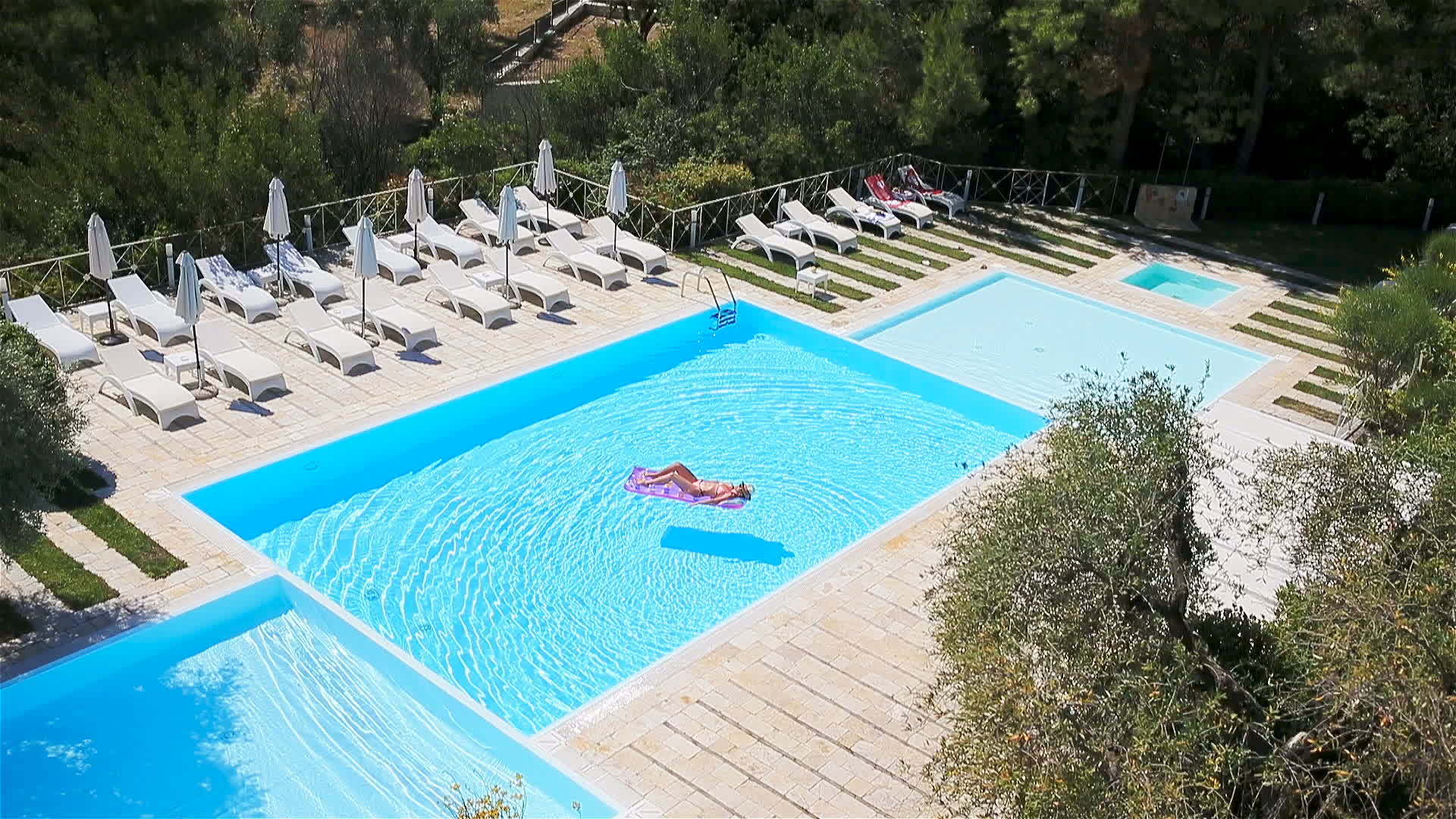 年轻女性在大游泳池的比基尼空气床垫中视频的预览图
