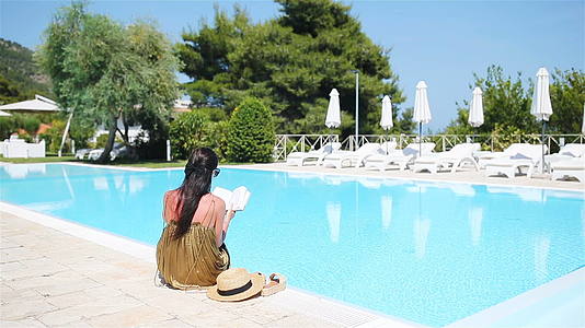女性在豪华酒店度假胜地的游泳池享受完美的海滩度假视频的预览图