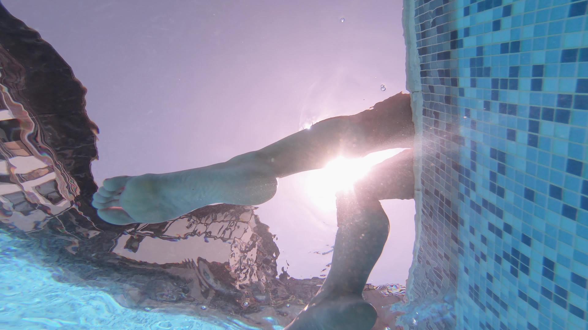 从一个性感女人的游泳池里她的腿在水下挥舞视频的预览图