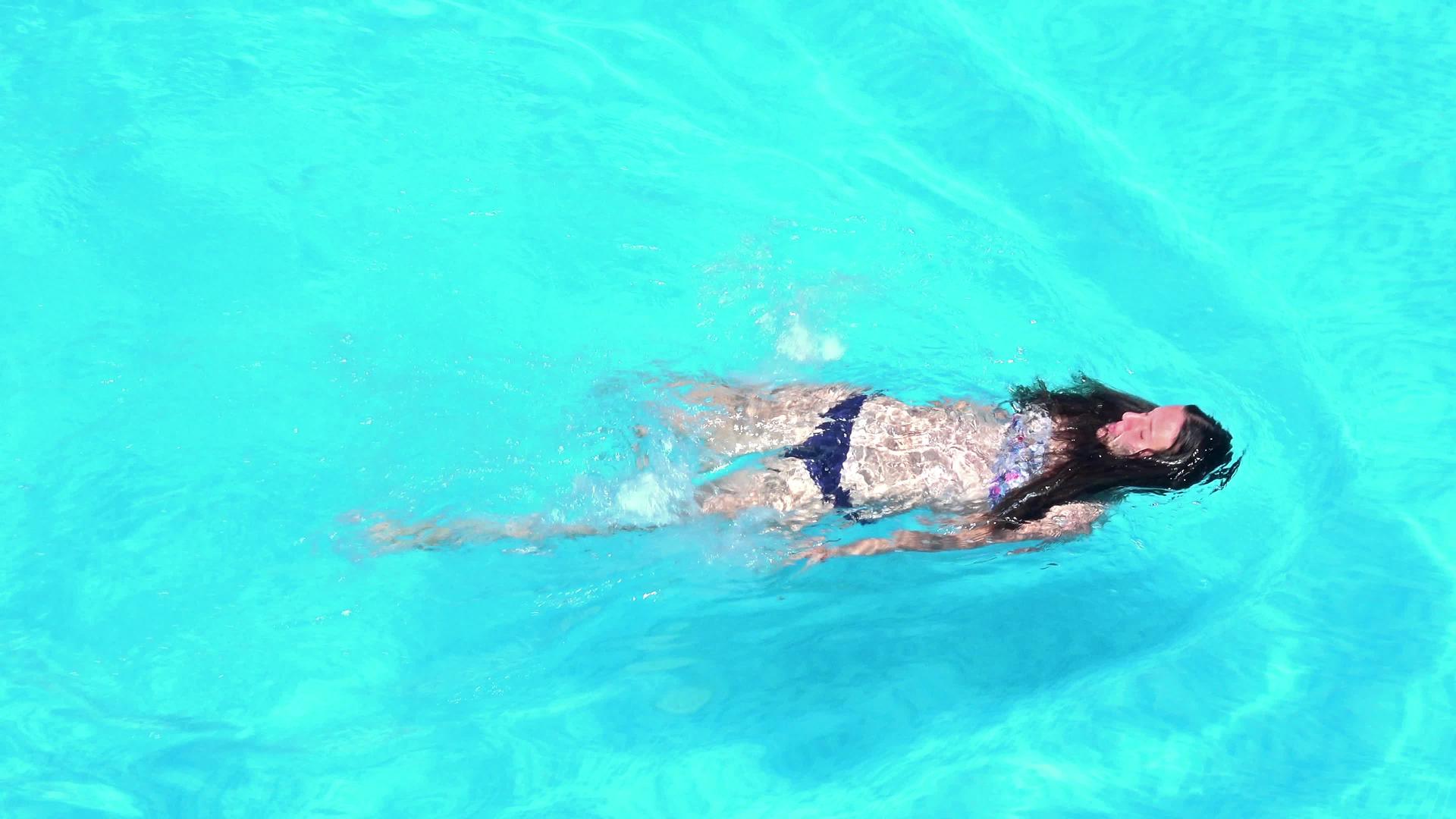 游泳池里年轻女子的顶部风景视频的预览图