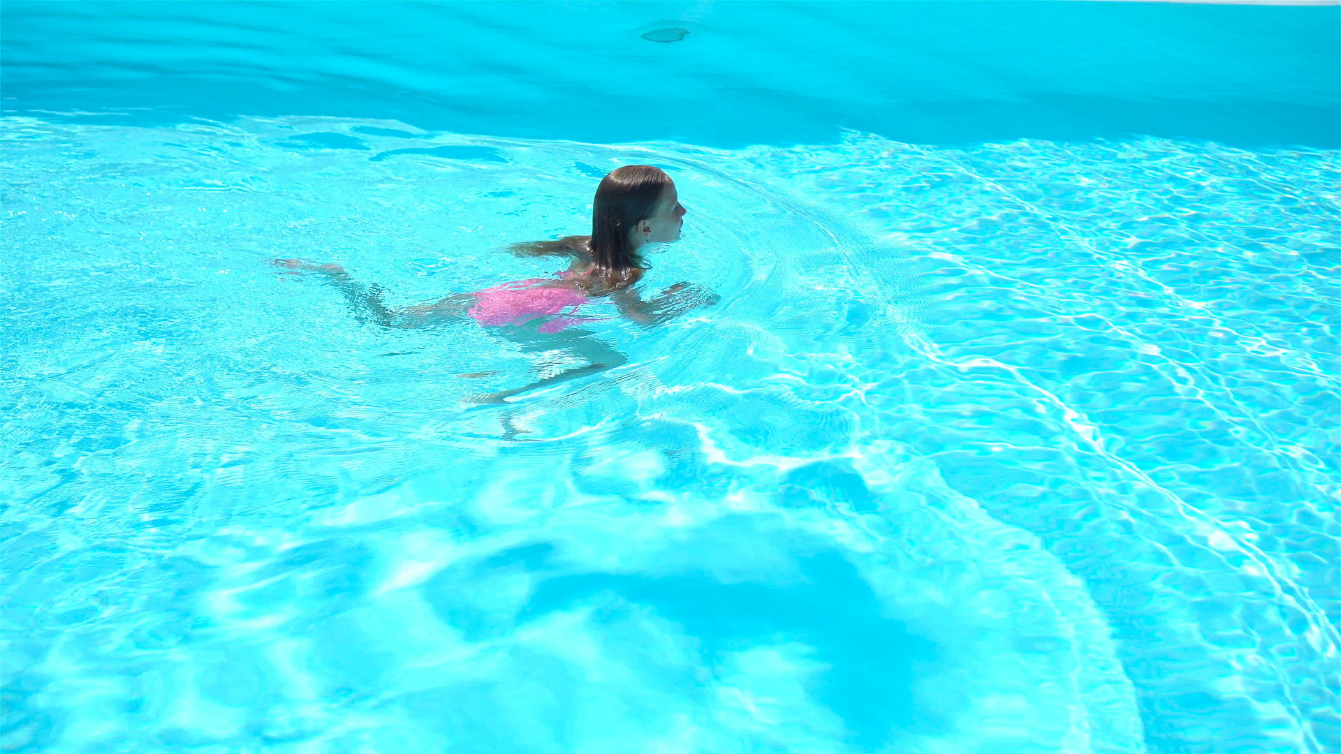 可爱的小女孩在户外游泳池里视频的预览图