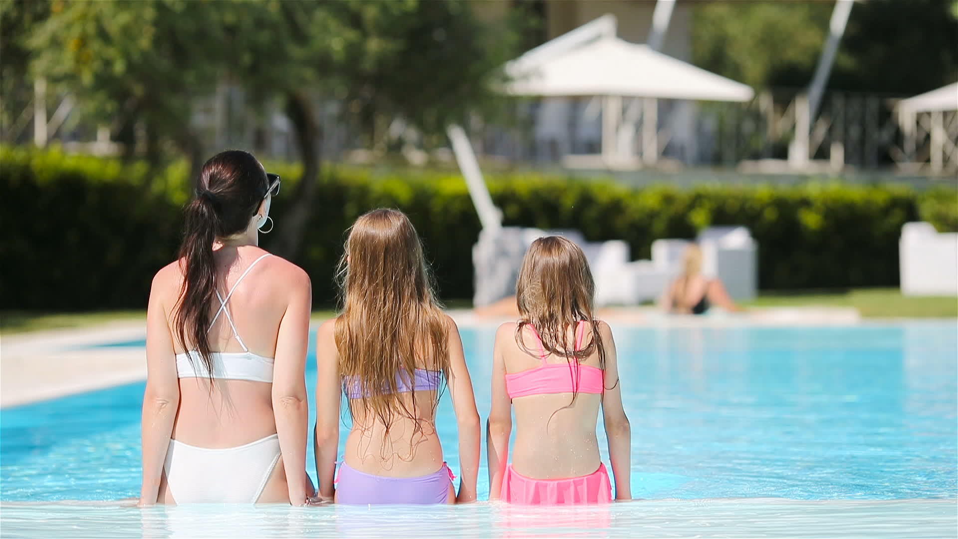 母亲和两个孩子在豪华游泳池度暑假视频的预览图
