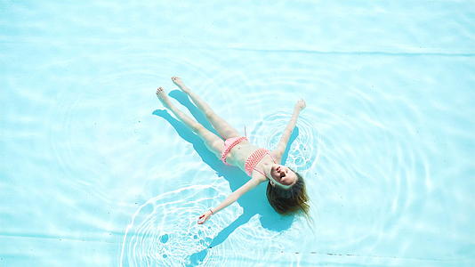 可爱美丽的小女孩在户外游泳池游泳视频的预览图