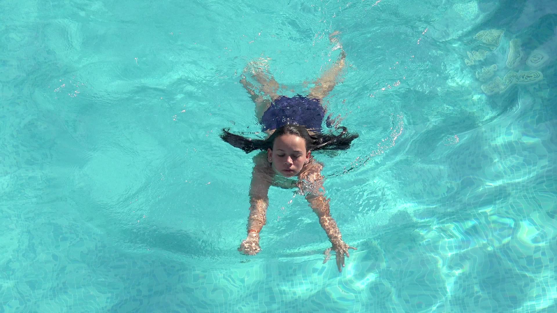 年轻女子在游泳池游泳在空中旅行视频的预览图
