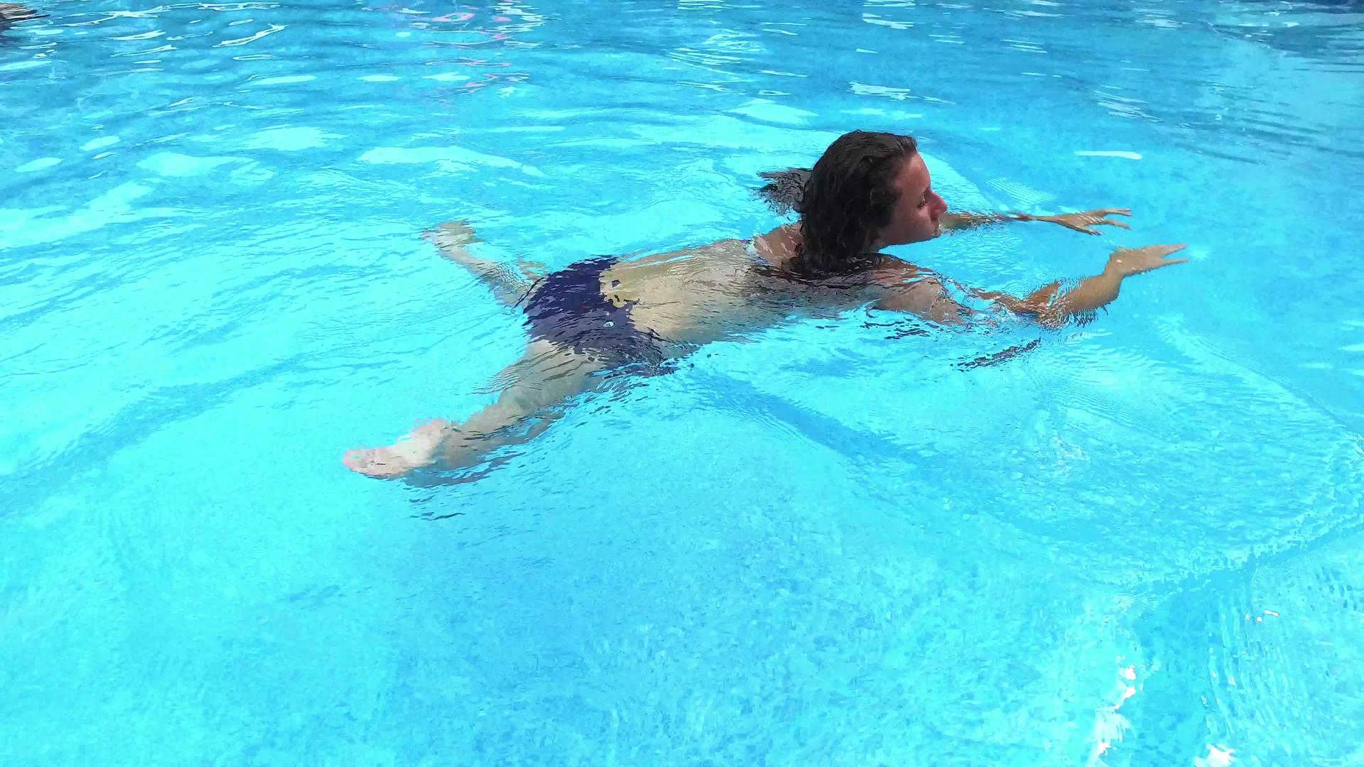 游泳池里一个女孩的顶部风景4K旅行镜头视频的预览图