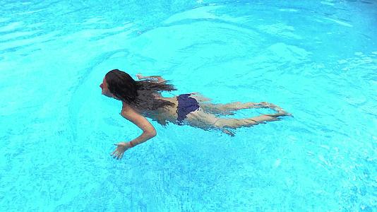 游泳池里一个女孩的顶部风景4K旅行镜头视频的预览图