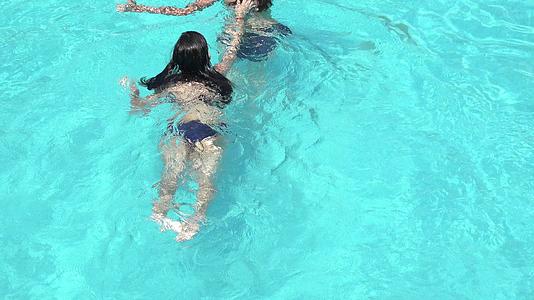 快乐的女孩在游泳池里玩暑假的概念视频的预览图