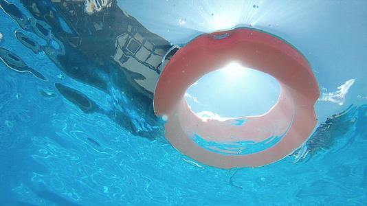 漂浮在阳光明媚的蓝色水面上慢慢移动水下风景视频的预览图