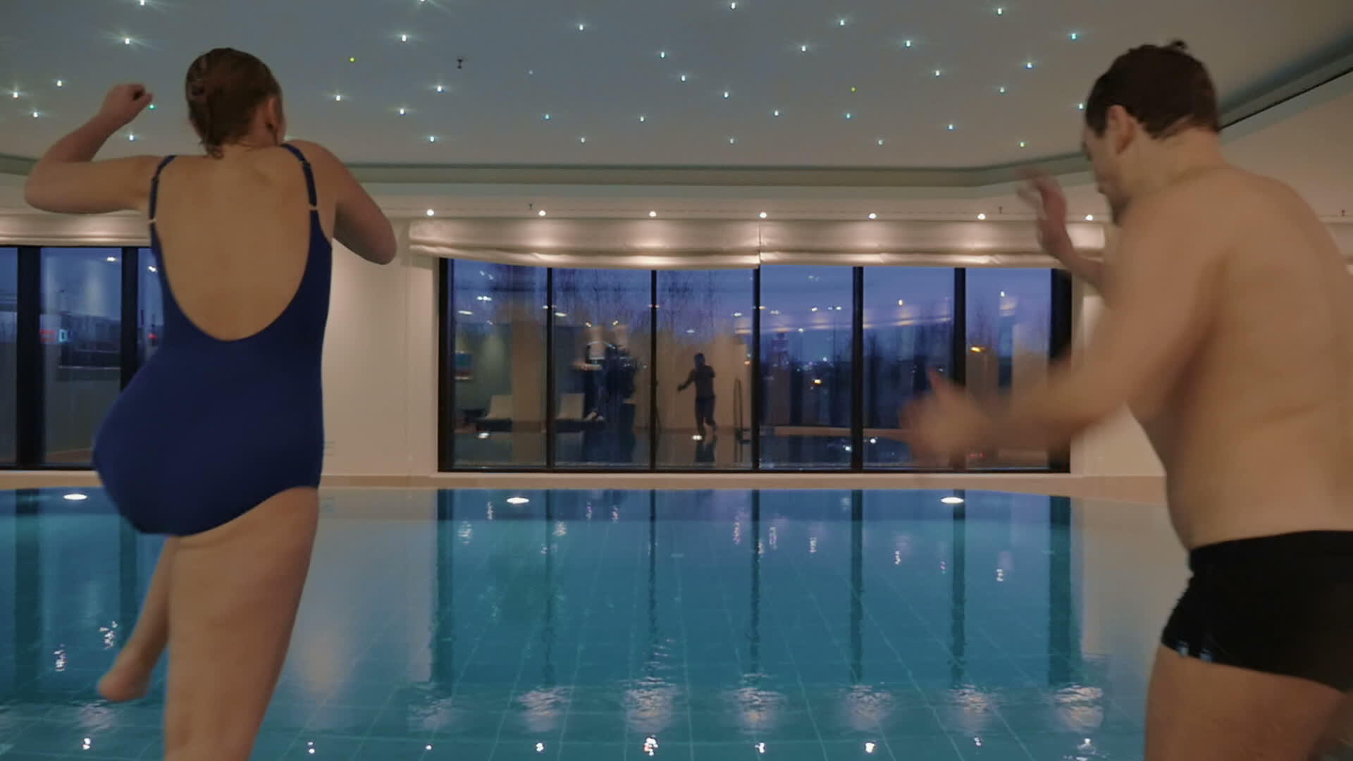 男人和女人跳进室内游泳池视频的预览图