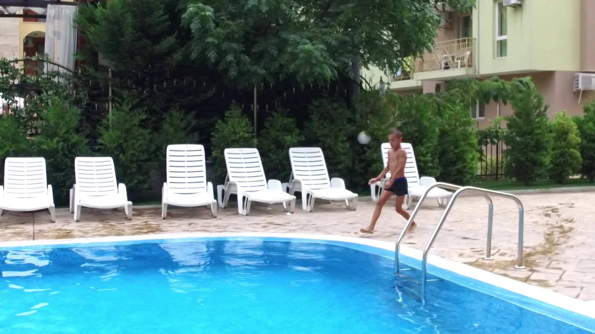 小男孩慢慢地跳进游泳池视频的预览图