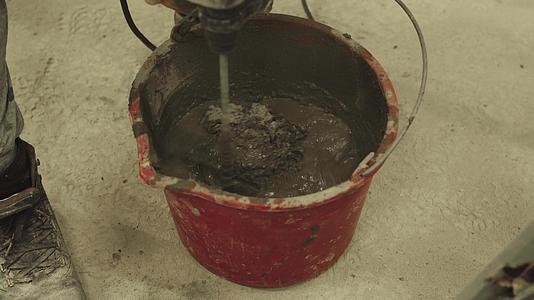 将水泥迫击炮与装有搅拌器的桶混合视频的预览图