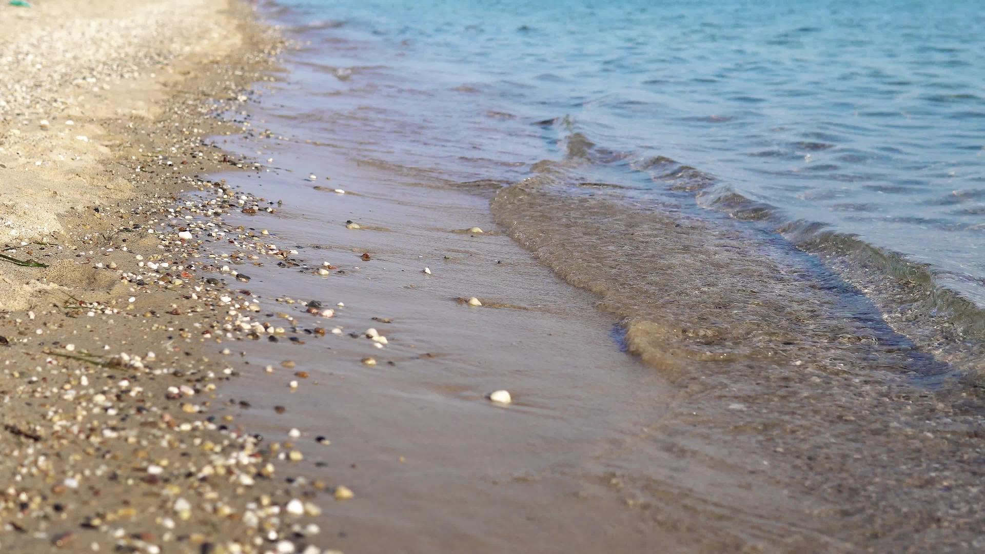 夏季概念背景海滩和平静的波浪席卷海滩、海滩和石头电影Dof视频的预览图