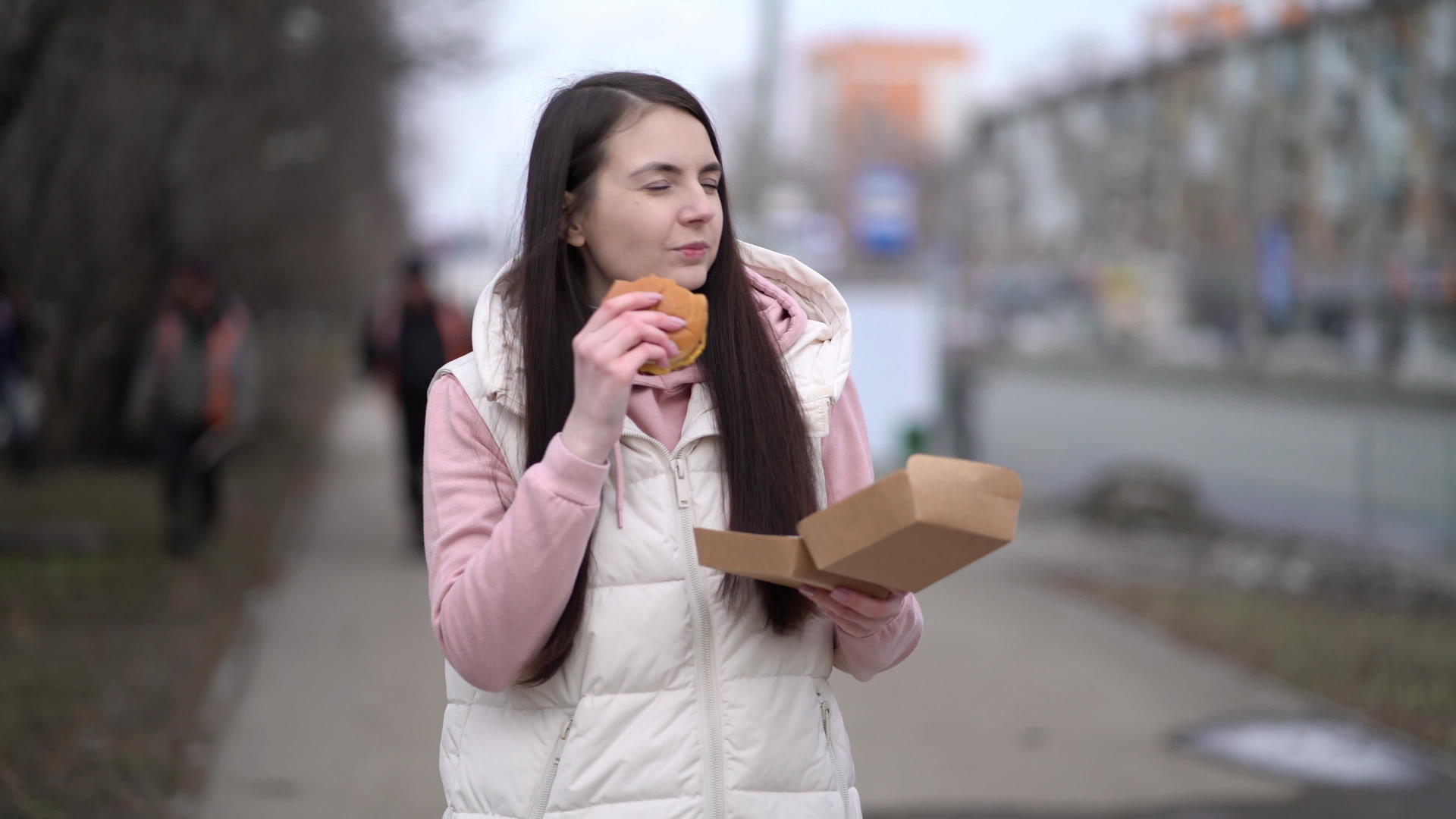 美女在城市户外散步吃汉堡吃汉堡视频的预览图