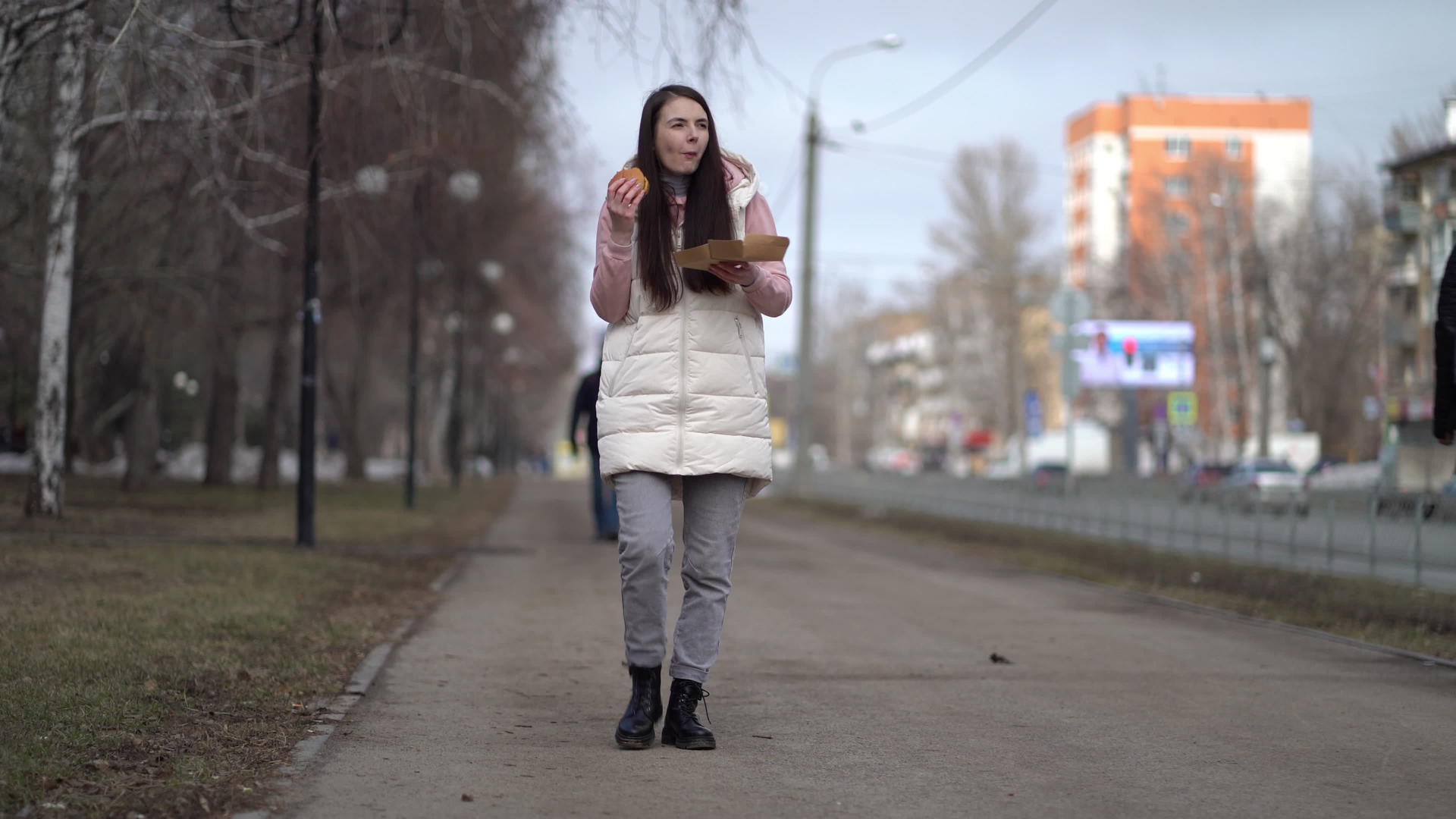 美女在城市户外散步吃汉堡吃汉堡视频的预览图