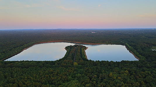 森林湖中的蓝水和黄昏中的绿色树木视频的预览图