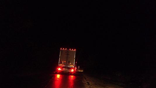 夜间下雨时农村道路上的卡车电影滑行镜头视频的预览图