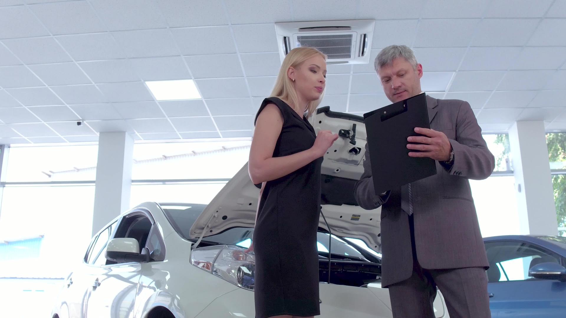 汽车展厅的汽车经销商和年轻女性视频的预览图